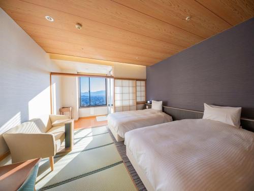 a hotel room with two beds and a window at Shoho in Matsumoto