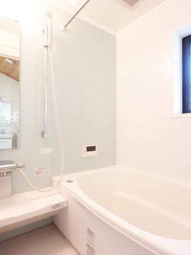a white bathroom with a tub and a sink at 青山庵 in Kyoto
