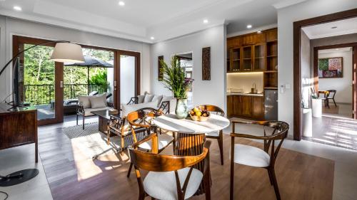 ein Esszimmer und ein Wohnzimmer mit Tisch und Stühlen in der Unterkunft The Pala Ubud by Elite Havens in Bedahulu