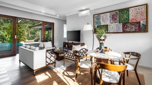 ein Wohnzimmer mit Tisch, Stühlen und Sofa in der Unterkunft The Pala Ubud by Elite Havens in Bedahulu