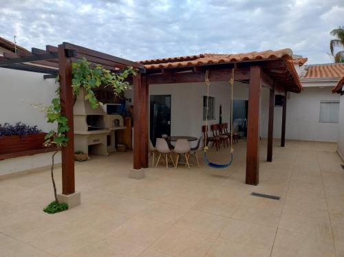 un pergolato con tavolo e sedie su un patio di Loft 03 - Zona Sul Prox UMC, Pátio Vinhedos e Shopping a Uberlândia
