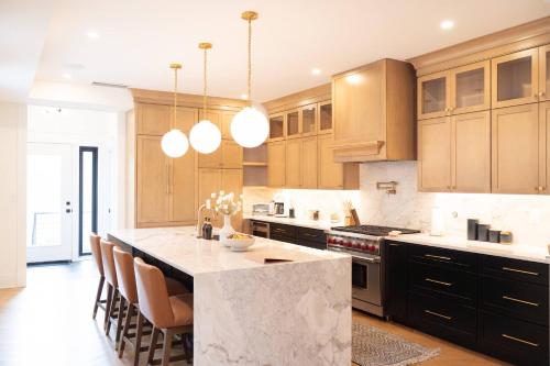 a kitchen with wooden cabinets and a marble counter top at NEW! LUX 4BR + Rooftop | Parking | Metro in Washington, D.C.