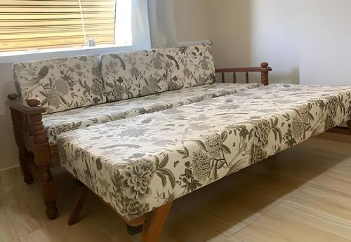 a couch sitting in a living room next to a window at Lindo flat - Cavalinho Branco - Águas de Lindóia in Águas de Lindóia
