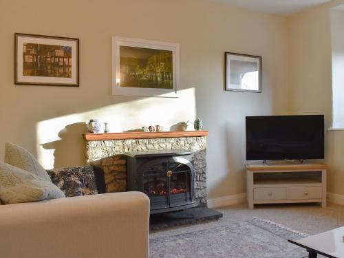 a living room with a fireplace and a television at Finlay's Cottage in Pickering