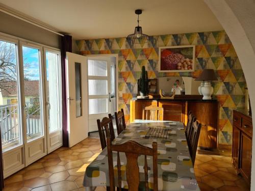 une salle à manger avec une table et des chaises dans l'établissement Gîte familial avec piscine partagée, cheminée et jardin clos près de Vichy - FR-1-489-76, à Creuzier-le-Neuf
