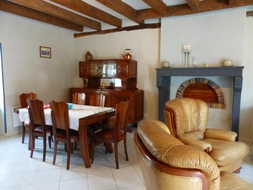 une salle à manger avec une table et une cheminée dans l'établissement Charmante maison rénovée avec cour, proche bourg, WiFi, jardin clos, animaux acceptés, à Louchy-Montfand - FR-1-489-178, à Louchy-Montfand