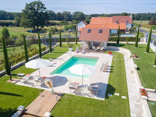 - une vue sur la piscine avec des chaises et une maison dans l'établissement Maison avec piscine chauffée, clim et jardin - Hauterives - FR-1-489-203, à Hauterive