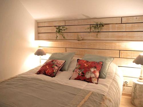 un letto con due cuscini sopra in una camera da letto di Loft cosy avec piscine et spa, à 10 min de Vichy, proche golf et nature - FR-1-489-337 a Cognat-Lyonne
