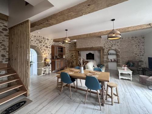 Il dispose d'une cuisine et d'un salon avec une table et des chaises en bois. dans l'établissement Gîte rustique rénové avec jeux pour enfants, climatisation et jardin privatif à Rocles - FR-1-489-546, à Rocles