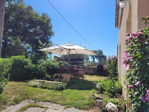 a patio with a table and an umbrella at Gîte familial avec terrasse à la ferme, proche Montluçon, idéal pour 4 pers, draps et serviettes inclus - FR-1-489-431 in Sauvagny