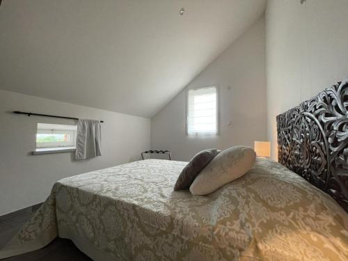 a bedroom with a bed with two pillows on it at Séjour détente avec piscine privée, activités variées et confort moderne en Auvergne - FR-1-489-455 in Louroux-Hodement