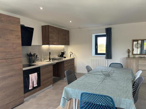 a kitchen with a table and chairs in a room at Fermette rénovée, tout confort, avec jardin et label "Tourisme et Handicap" en pleine campagne - FR-1-489-506 in Franchesse