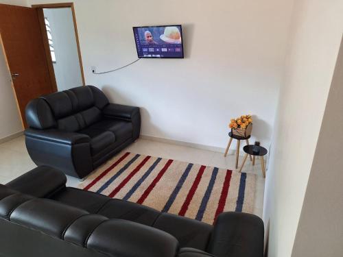 ein Wohnzimmer mit einer Couch und einem Sessel in der Unterkunft Privacidade para sua família e grupos em um só lugar-2 quartos- melhor custo-benefício, garagem, sala com cozinha integrada, aconchegante, ambiente moderno e funcional, wi-fi veloz gratuito, próximo ao Parque das Águas-Calçadão e tudo que a cidade oferece in São Lourenço