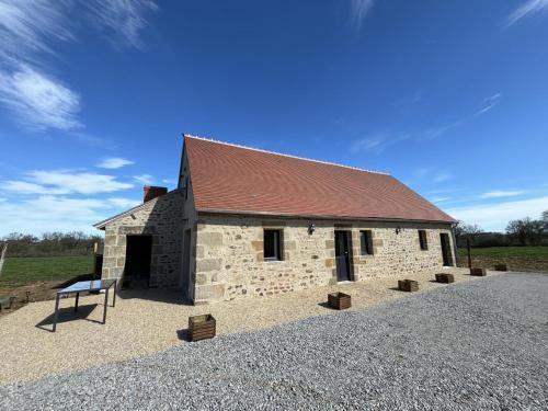 a stone building with a brown roof on a field at Fermette rénovée, tout confort, avec jardin et label "Tourisme et Handicap" en pleine campagne - FR-1-489-506 in Franchesse