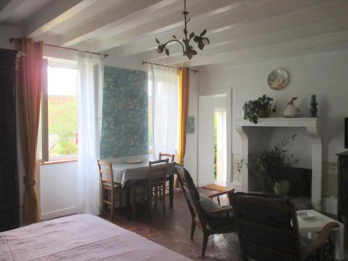 une pièce avec une table et des chaises et une salle à manger dans l'établissement Charmant cottage rénové avec jardin privé, cheminée, proche forêt, commerces et loisirs - FR-1-489-377, à Lurcy-Lévis