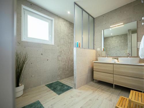 un bagno con due lavandini e uno specchio di Gîte charmant avec spa, terrasse et grand jardin au cœur des vignobles historiques - FR-1-489-513 a Saulcet
