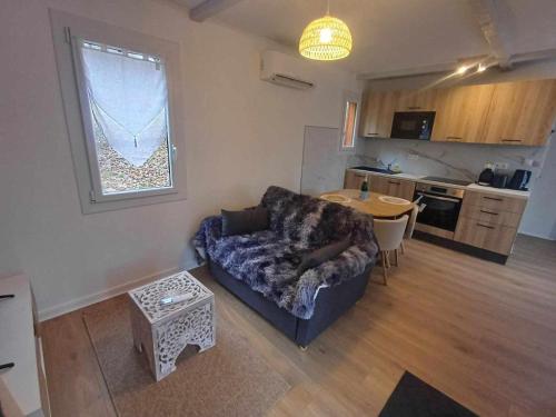 un salon avec un canapé et une table dans l'établissement Gîte champêtre confortable avec terrasse et jardin - FR-1-489-564, à Jenzat