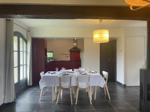 une salle à manger avec une table et des chaises blanches dans l'établissement Maison de Charme avec Jardin Privé et Randonnées, Idéale pour Familles et Cavaliers - FR-1-489-449, à Autry-Issards
