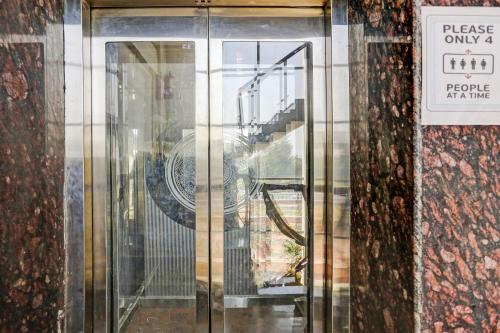 a glass door of a building with a sign on it at Hotel O S.N Sky Awadh in Lucknow