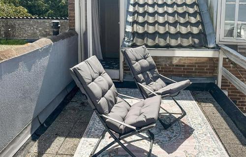 two chairs sitting on top of a porch at 1 Bedroom Awesome Home In Katwijk Aan Zee in Katwijk aan Zee