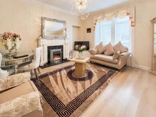 a living room with a couch and a fireplace at Beachcomber Apartment in Girvan