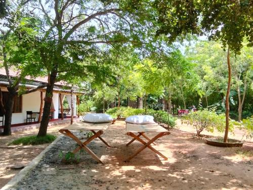 two picnic tables with pillows on them in a park at Bundala Resort in Tissamaharama