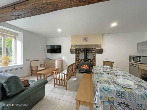 un salon avec une table et une cheminée dans l'établissement Maison Normande Authentique, Accessible PMR, Animaux Bienvenus, Activités Nature et Calme Assuré - FR-1-497-74, à Saint-Fraimbault-sur-Pisse