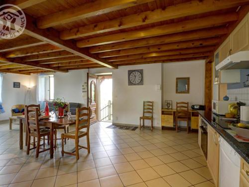 une cuisine et une salle à manger avec une table et des chaises dans l'établissement Gîte chaleureux à 15 min de St-Etienne, 2 chambres, terrasse, jardin, animaux acceptés - FR-1-496-4, à Saint-Héand