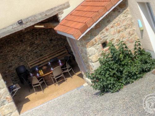 an outdoor patio with a table and chairs in a building at Gîte rénové avec fibre et confort à Panissières - FR-1-496-367 in Panissières