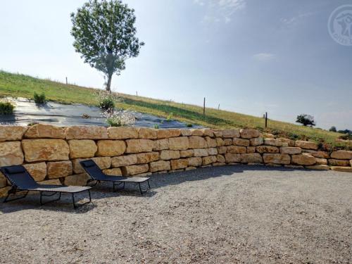 two chairs sitting next to a stone wall at Gîte rénové avec fibre et confort à Panissières - FR-1-496-367 in Panissières