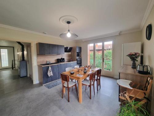 une cuisine et une salle à manger avec une table et des chaises dans l'établissement Gîte spacieux avec terrasse, cheminée, wifi et parking à Roanne - FR-1-496-337, à Roanne