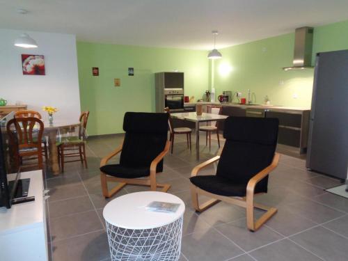 un salon avec des chaises et une table et une cuisine dans l'établissement Appartement PMR, balcon, cuisine équipée, WiFi, draps fournis - FR-1-496-228, à Saint-Genest-Malifaux