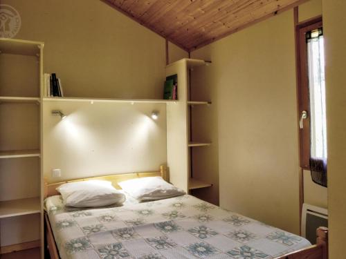 a bedroom with a bed with two pillows on it at Chalet accessible PMR avec terrasse et animaux acceptés - FR-1-496-243 in Saint-Rirand