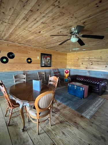 a dining room with a table and chairs and a couch at The Blues House Yellow Rose Canyon in Mount Enterprise