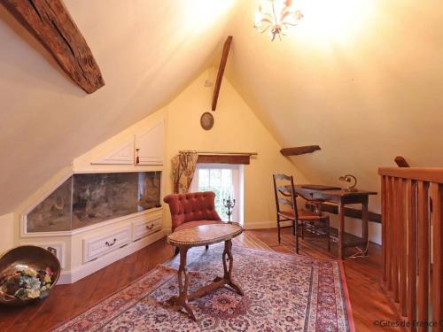 un salon avec un grand aquarium et une table dans l'établissement Maison indépendante avec jardin privatif, cheminée et accès direct à la forêt - FR-1-497-180, à Saint-Pierre-des-Loges