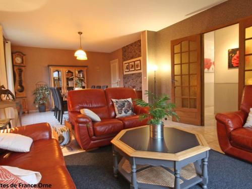 a living room with leather furniture and a table at Maison familiale avec jardin clos près du Haras National du Pin - FR-1-497-173 in Le Merlerault