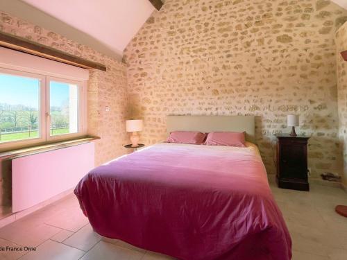 a bedroom with a large bed and a window at Charmante maison en pierres restaurée, WIFI, 2 ch. - FR-1-497-241 in La Mesniere