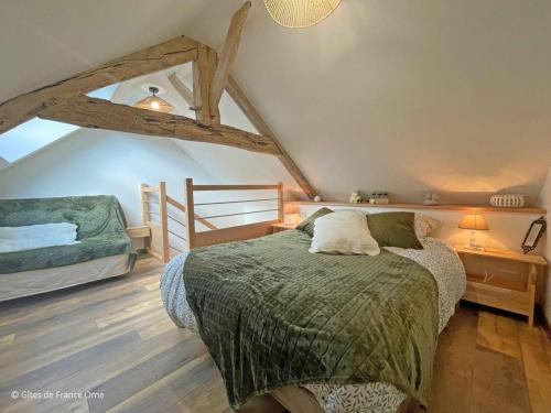 ein Schlafzimmer mit einem Bett auf einem Dachboden in der Unterkunft Charme rustique près de Bagnoles, animaux admis, jardin et WiFi inclus - FR-1-497-222 in La Coulonche