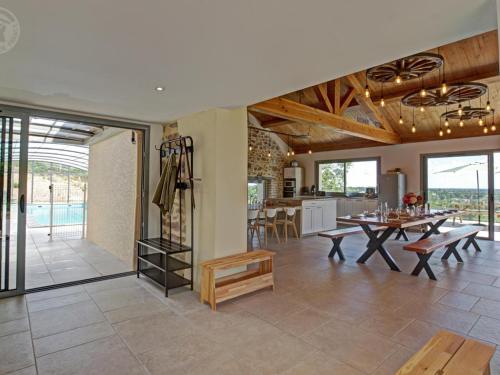 a kitchen and living room with a table and a dining room at Grande maison rénovée avec piscine chauffée, salle de jeux, pour 14 pers. à Sail-les-Bains - FR-1-496-301 in Sail-les-Bains