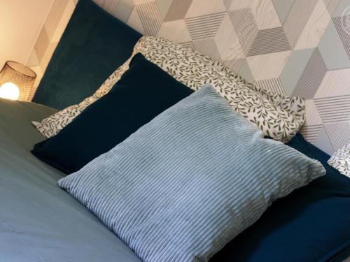 a bed with a pillow on it with a wall at Grande maison rénovée avec piscine chauffée, salle de jeux, pour 14 pers. à Sail-les-Bains - FR-1-496-301 in Sail-les-Bains