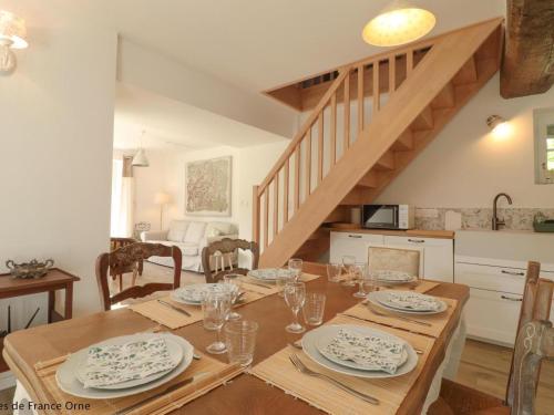 - une salle à manger avec une table et des assiettes dans l'établissement Charmante longère avec grand jardin, proche Saint-Fraimbault - FR-1-497-246, à Saint-Fraimbault-sur-Pisse