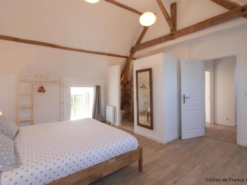 a bedroom with a white bed and a mirror at Longère avec Jardin Exotique, Terrasse et Wifi Inclus - FR-1-497-246 in Saint-Fraimbault