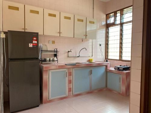 a kitchen with a refrigerator and a sink at Staycation Taiping Homestay in Taiping