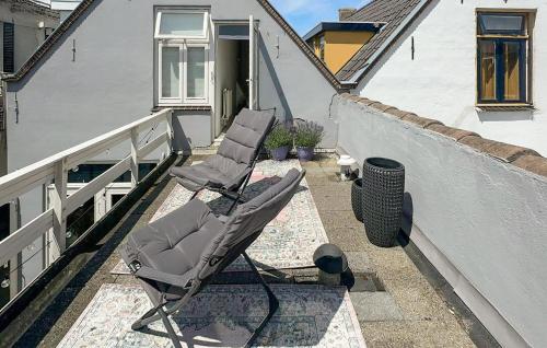 a pair of chairs sitting on a balcony at 1 Bedroom Awesome Home In Katwijk Aan Zee in Katwijk aan Zee