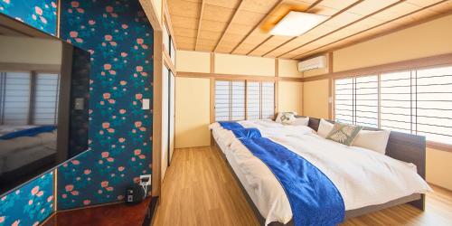 a bedroom with a large bed and a tv at Awaji Kusaka Jungle in Awaji