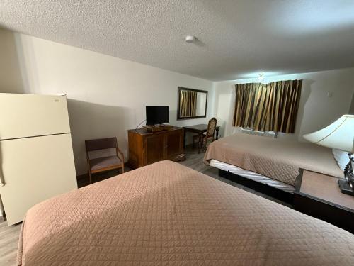a hotel room with two beds and a desk at Island Inn in Grand Island