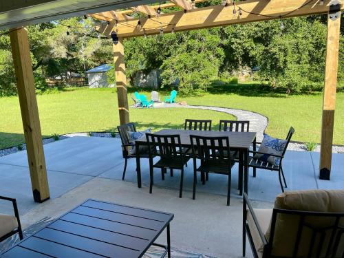 a patio with a table and chairs under a pergola at Pensacola Coastal Retreat Near UWF Family-friendly in Olive