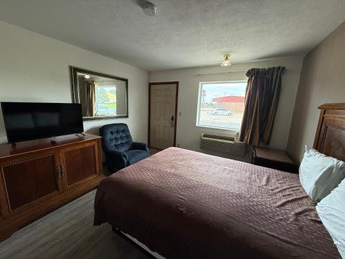 a hotel room with a bed and a flat screen tv at Island Inn in Grand Island