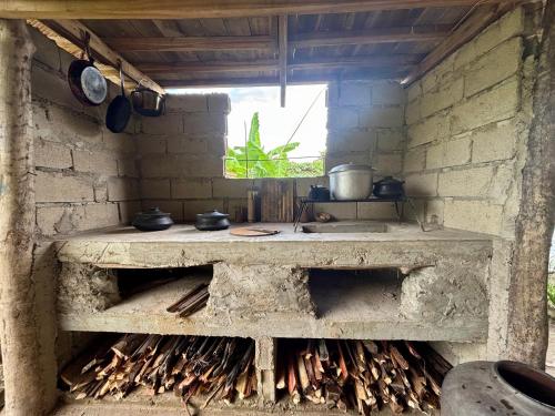 a kitchen with a stone stove with a window at El Trinidad Organic Farm in El Nido