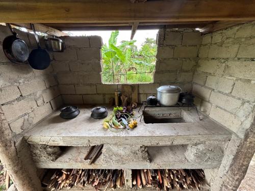a stone kitchen with a stove and some pots and pans at El Trinidad Organic Farm in El Nido